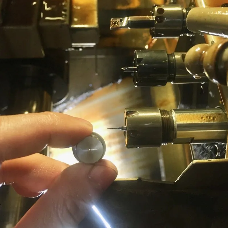 SUS304 不鏽鋼 Ø16×16mm 件，Ø0.4 貫穿孔，機台旁實拍